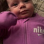 baby, infant, purple_clothing, nike, onesie, face, eyes, blanket, quilt, close_up, portrait, child, cute, soft_lighting, indoor, young, skin, head, expression, warm