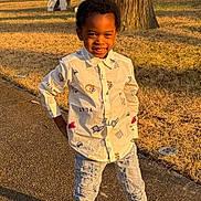 Zayne joined the competition — help win amazing prizes! child, boy, smiling, standing, outdoor, daylight, jeans, shirt, sneakers, playground, tree_stump, grass, pathway, sunlight, casual_clothing, happy, posing, nature, yard, playtime
