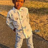 Zayne joined the competition — help win amazing prizes! child, boy, smiling, standing, outdoor, sunlight, grass, tree_stump, white_shoes, ripped_jeans, patterned_shirt, pavement, casual_clothing, happy, daylight, yard, plastic_chair, nature, portrait, young