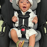 Nolan joined the competition — help win amazing prizes! baby, infant, car_seat, smiling, hat, white_clothing, sandal, footwear, black_car_seat, child, happy, straps, safety_harness, indoors, cute, person, seat, headwear, face, young