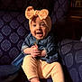 baby, bodypart, bonnet, cap, chair, clothing, couch, face, finger, furniture, hand, happy, hat, head, pants, person, photography, portrait, sitting, smile