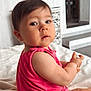 baby, child, infant, pink_clothing, sitting, blanket, indoors, face, curious, cute, skin, short_hair, expression, person, young, soft_light, home, floor, room, portrait
