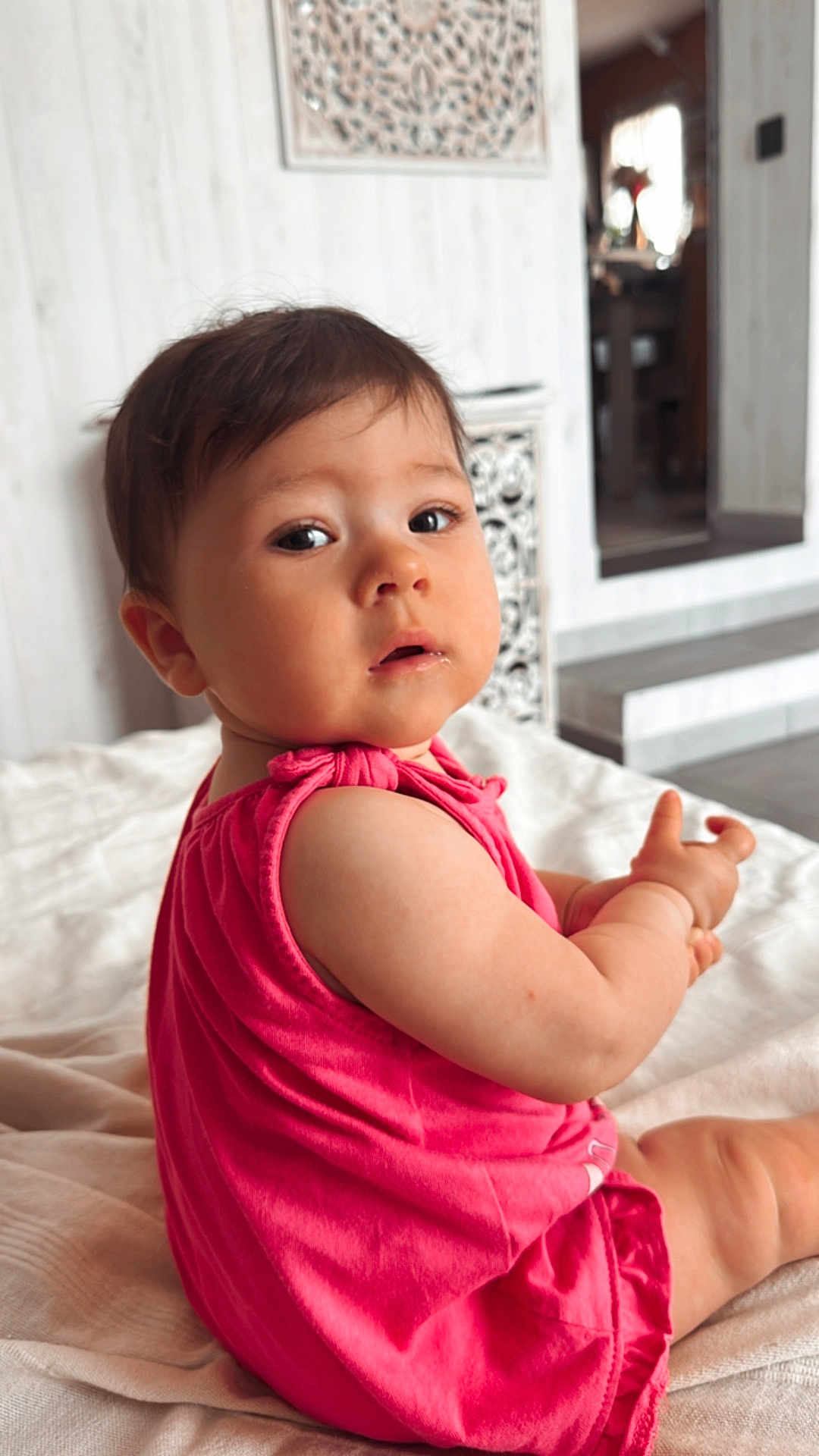 Nina participe au concours pour gagner de l'argent avec cette photo : baby, child, infant, pink_clothing, sitting, blanket, indoors, face, curious, cute, skin, short_hair, expression, person, young, soft_light, home, floor, room, portrait