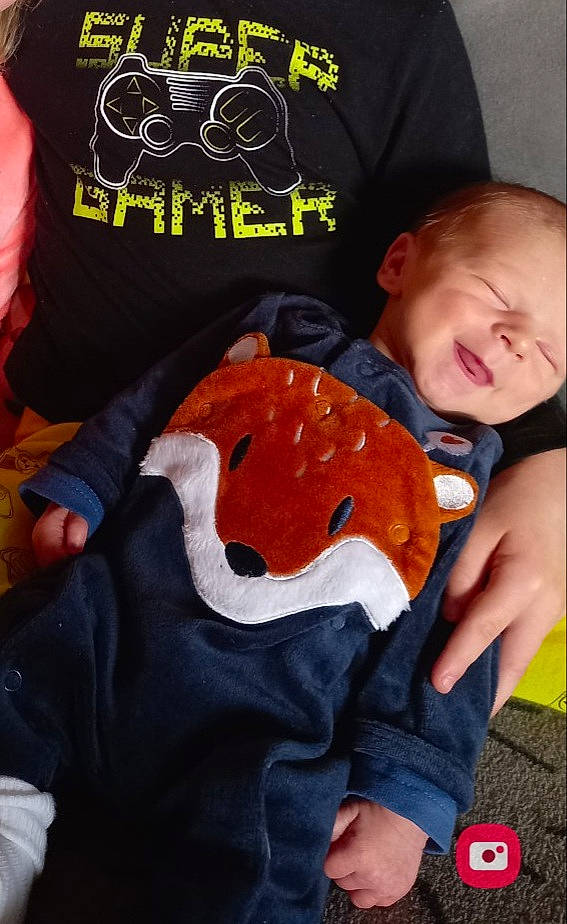 Noah a rejoint le concours — aidez-le/la à gagner de superbes lots ! baby, baby_products, baby_toddler_clothing, cheek, child, comfort, cool, finger, fun, gesture, happy, mouth, orange, person, sitting, sleeve, smile, t_shirt, textile, thumb