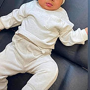 Ziggy joined the competition — help win amazing prizes! baby, infant, child, knit_hat, cream_clothing, long_sleeve, pants, black_sock, couch, leather, seated, indoors, cute, curious, wide_eyes, small_ears, soft_texture, comfortable, portrait, fashion
