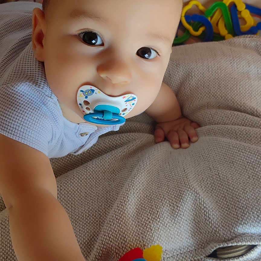 Hugo participe au concours pour gagner de l'argent avec cette photo : applique, baby, blanket, bodypart, couch, crawling, cushion, face, finger, furniture, hand, head, newborn, pattern, person, photography, portrait, rattle, sitting, toy