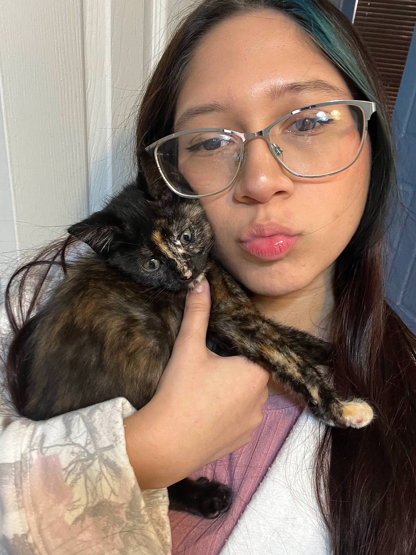 Ponyo is registered to the contest to win money with this photo: affection, casual_clothing, cat, closeup, cozy, cute, expression, face, glasses, hand, holding, indoor, kitten, long_hair, pet, portrait, tortoiseshell_cat, warm_lighting, woman, young_adult