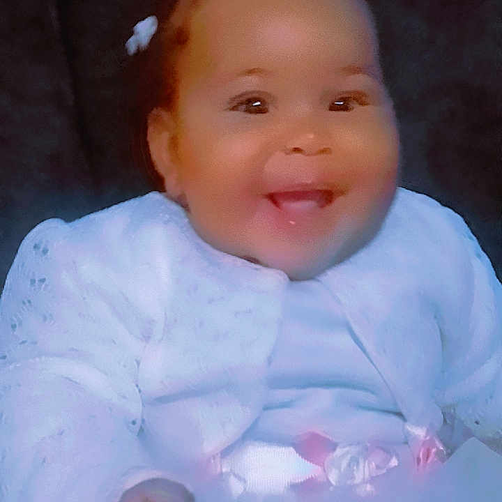 Zaylani joined the competition — help win amazing prizes! baby, celebration, child, colorful, cute, dark_background, dress, face, female, fun, hand, happy, heart_emoji, infant, joyful, portrait, sitting, smiling, white_clothing, young_child