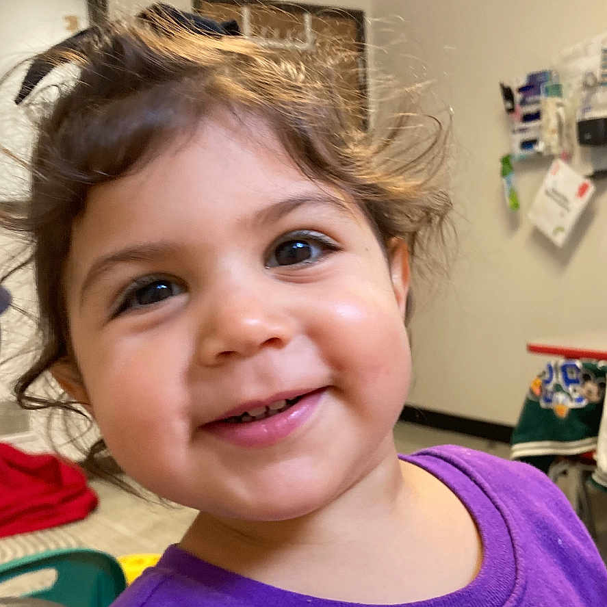 Domila joined the competition — help win amazing prizes! child, toddler, smiling, purple_shirt, indoor, face, portrait, happy, hair, young_child, cute, person, eyes, clothing, background, room, wall, furniture, casual, expression