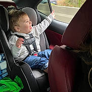 Leelend joined the competition — help win amazing prizes! toddler, child, car_seat, safety_harness, car_interior, window, smiling, happy, jeans, hoodie, seat, automobile, travel, seatbelt, young_child, person, casual_clothing, daytime, nature_outside, road
