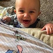 Carter joined the competition — help win amazing prizes! baby, smiling, child, infant, overalls, carpet, toy, happy, cute, face, hands, indoor, floor, clothing, person, playful, peek, expression, closeup, home