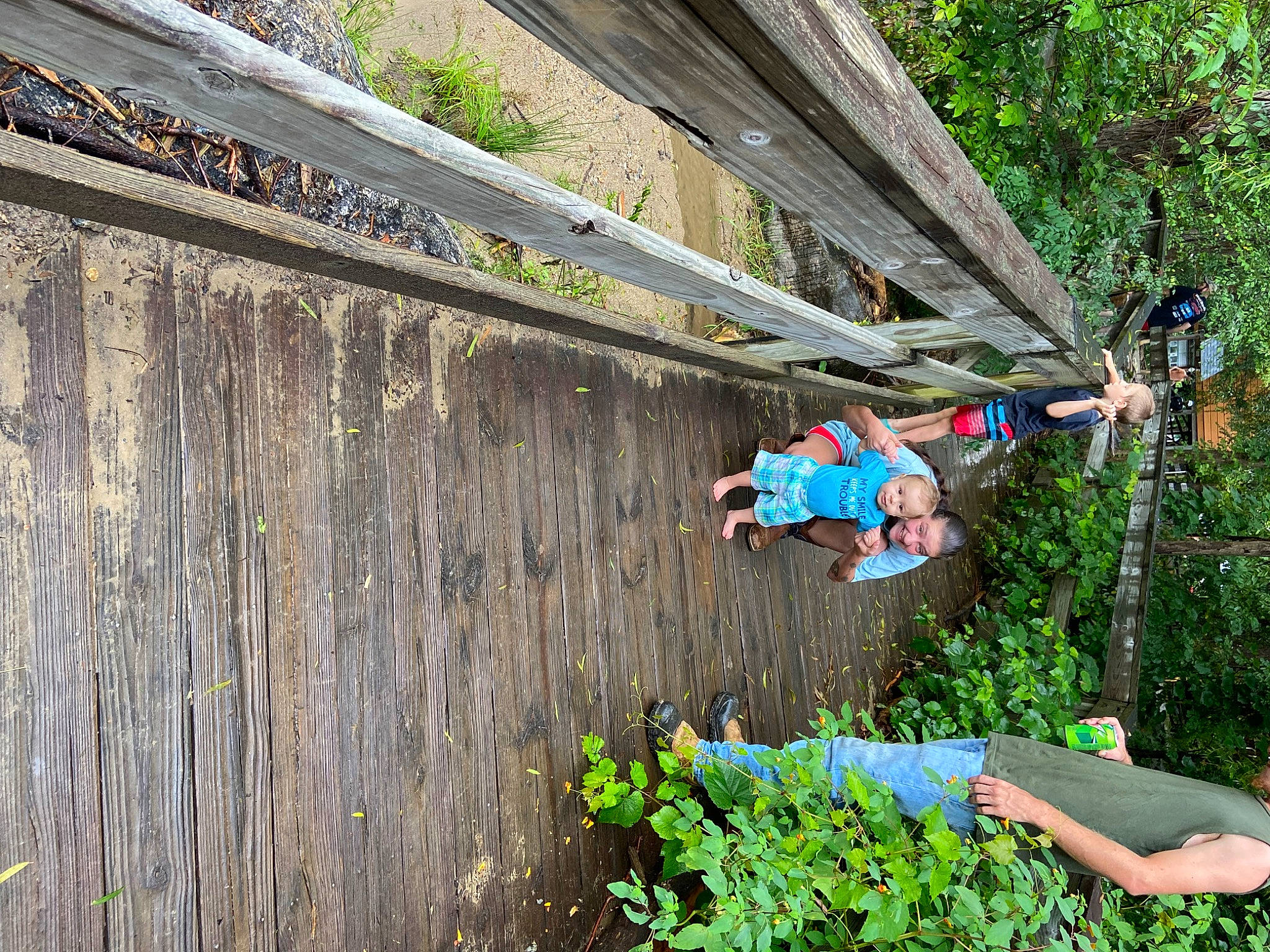 William is registered to the contest to win money with this photo: adventure, bridge, climbing_harness, forest, fun, grass, joy, jungle, landscape, leisure, people_in_nature, person, plant, recreation, rope, shorts, shrub, slope, soil, sport_climbing