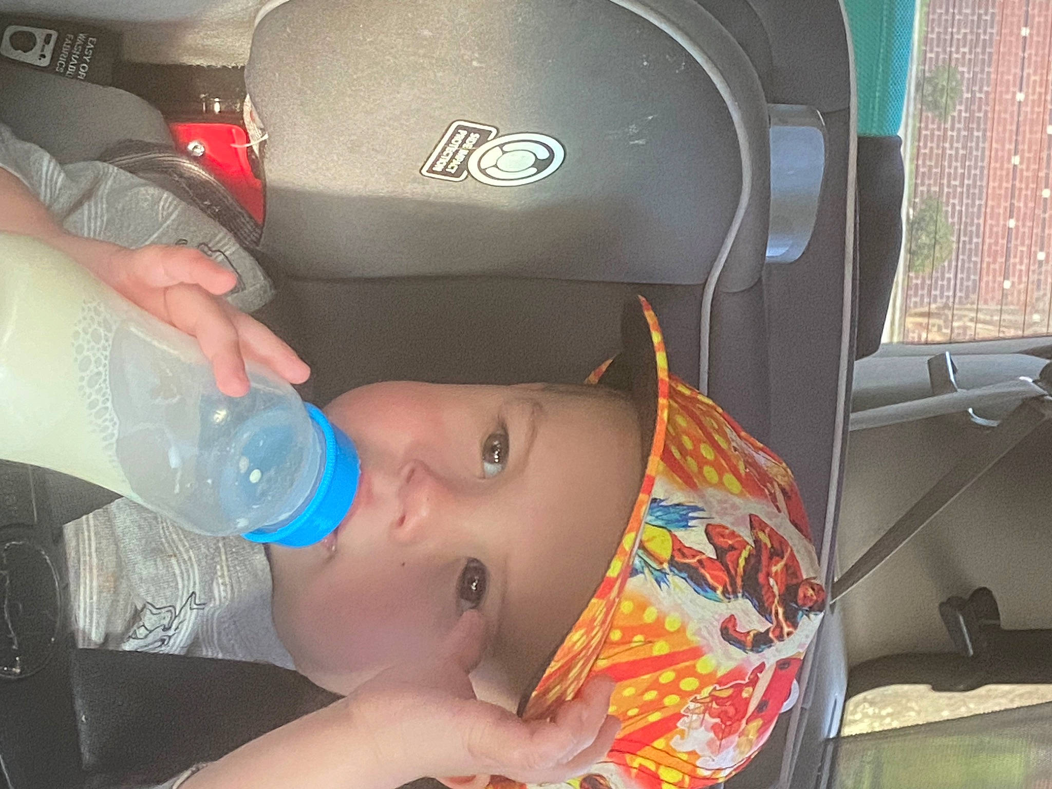 William joined the competition — help win amazing prizes! automotive_design, baby, baby_bottle, bottle, car_seat, child, comfort, drinking_water, drinkware, finger, hat, headwear, mouth, nail, person, plastic_bottle, product, skin, toddler, vehicle_door