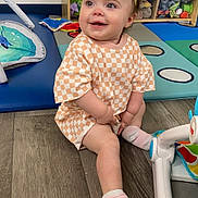 Isabella is registered to the contest to win money with this photo: baby, clothing, couch, dress, face, footwear, furniture, hardwood, hat, head, hosiery, indoors, interiordesign, person, photography, portrait, shoe, sitting, sock, wood