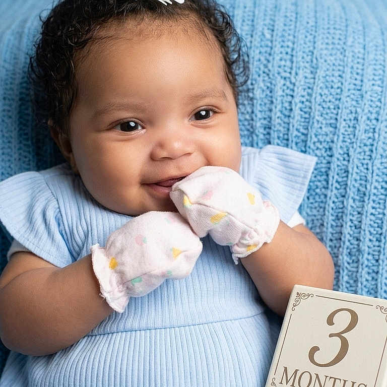 Azure is registered to the contest to win money with this photo: baby, infant, blue_clothing, mittens, flower_headband, smiling, portrait, three_months, milestone, soft_texture, blanket, cute, happy, child, sitting, young_baby, indoors, closeup, adorable, baby_girl