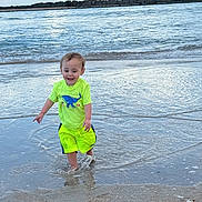 Colton joined the competition — help win amazing prizes! toddler, child, water, beach, ocean, splashing, neon_clothing, yellow_shorts, yellow_shirt, happy, smiling, sand, waves, sky, clouds, outdoor, summer, vacation, nature, play