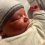 newborn, baby, sleeping, hat, blanket, infant, closeup, face, hand, cozy, soft_lighting, indoors, portrait, child, cute, resting, knitted, warm, toddler, peaceful