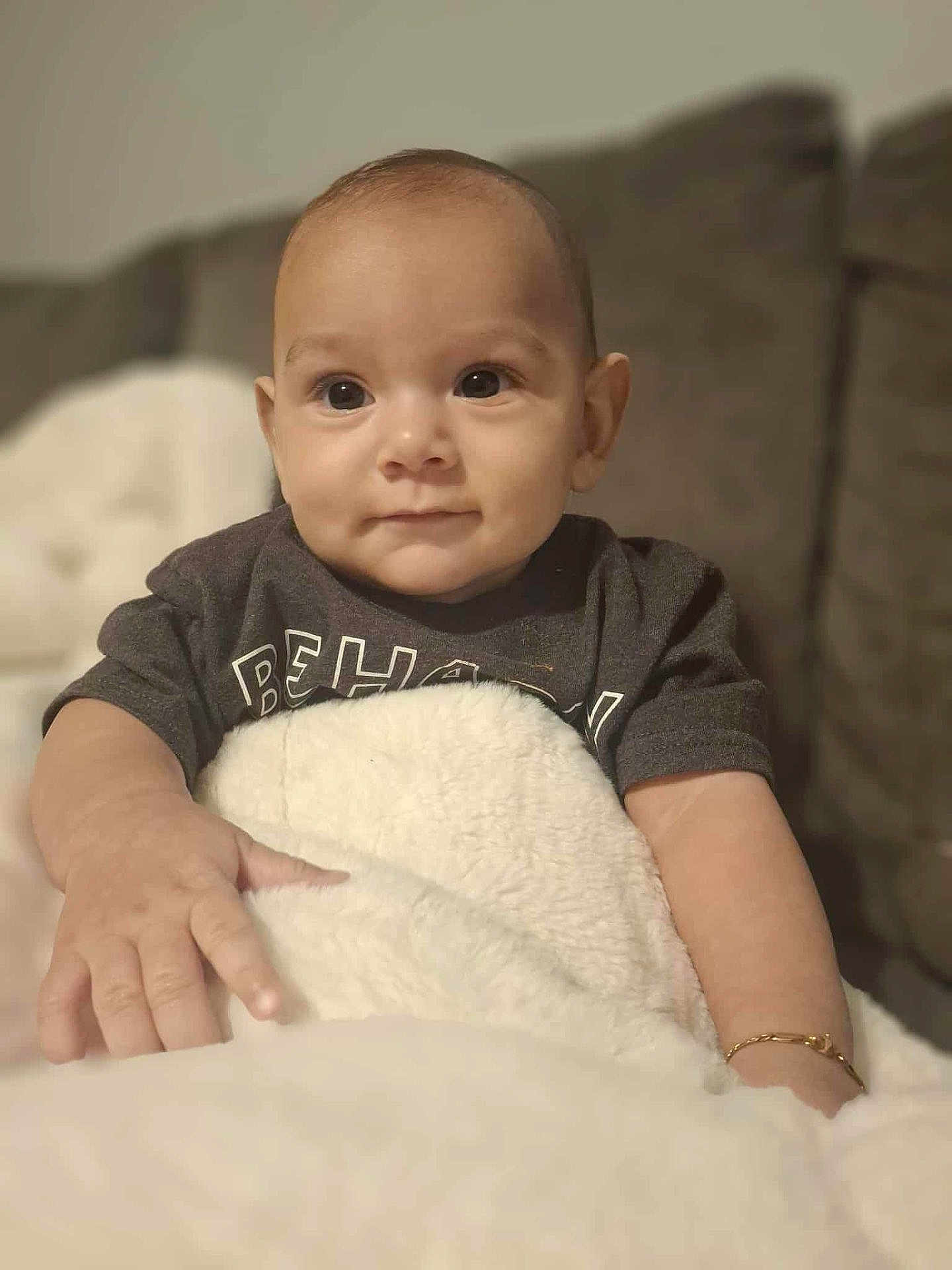 Keanu is registered to the contest to win money with this photo: baby, child, blanket, couch, face, infant, person, portrait, smiling, toddler, clothing, jewelry, bracelet, hand, indoor, furniture, soft, warm, cute, young