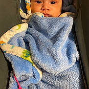 Keanu is registered to the contest to win money with this photo: baby, blanket, blue, pacifier, infant, face, wrapped, cozy, soft, child, cute, warm, sleepy, hooded, fuzzy, person, newborn, indoor, comfort, rest