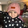 Serenity is registered to the contest to win money with this photo: toddler, child, hat, knit_hat, pom_poms, polka_dot, jacket, black_jacket, indoor, ceiling_fan, face, smile, warm_lighting, person, portrait, cute, cozy, winter_clothing, headwear, young_child