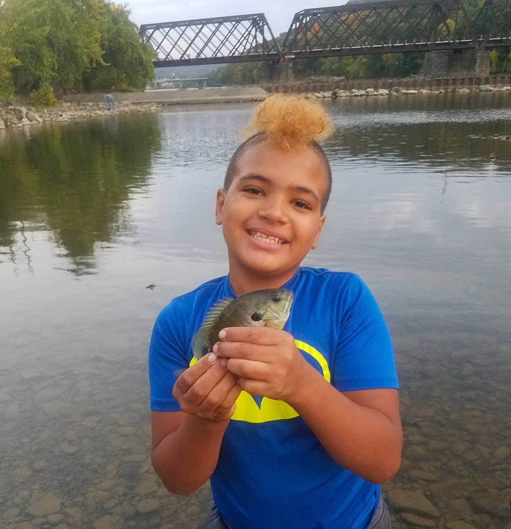 Tyson is registered to the contest to win money with this photo: arm, bank, body_of_water, bridge, channel, elbow, finger, girder_bridge, hand, human, joy, lake, person, reservoir, river, t_shirt, thumb, vacation, water, water_resources