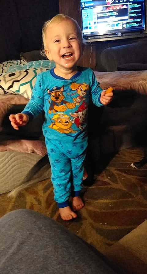 Xavier is registered to the contest to win money with this photo: arm, baby, baby_toddler_clothing, cheek, child, facial_expression, fictional_character, fun, head, pajamas, person, play, product, skin, sleeve, smile, standing, t_shirt, thumb, toddler