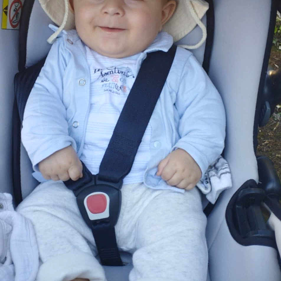 Nadir participe au concours pour gagner de l'argent avec cette photo : baby, baby_clothes, blanket, bucket_hat, car, car_seat, child, clothing, cute, face, footwear, happy, headwear, infant, outdoor, safety, seatbelt, sitting, smile, straps
