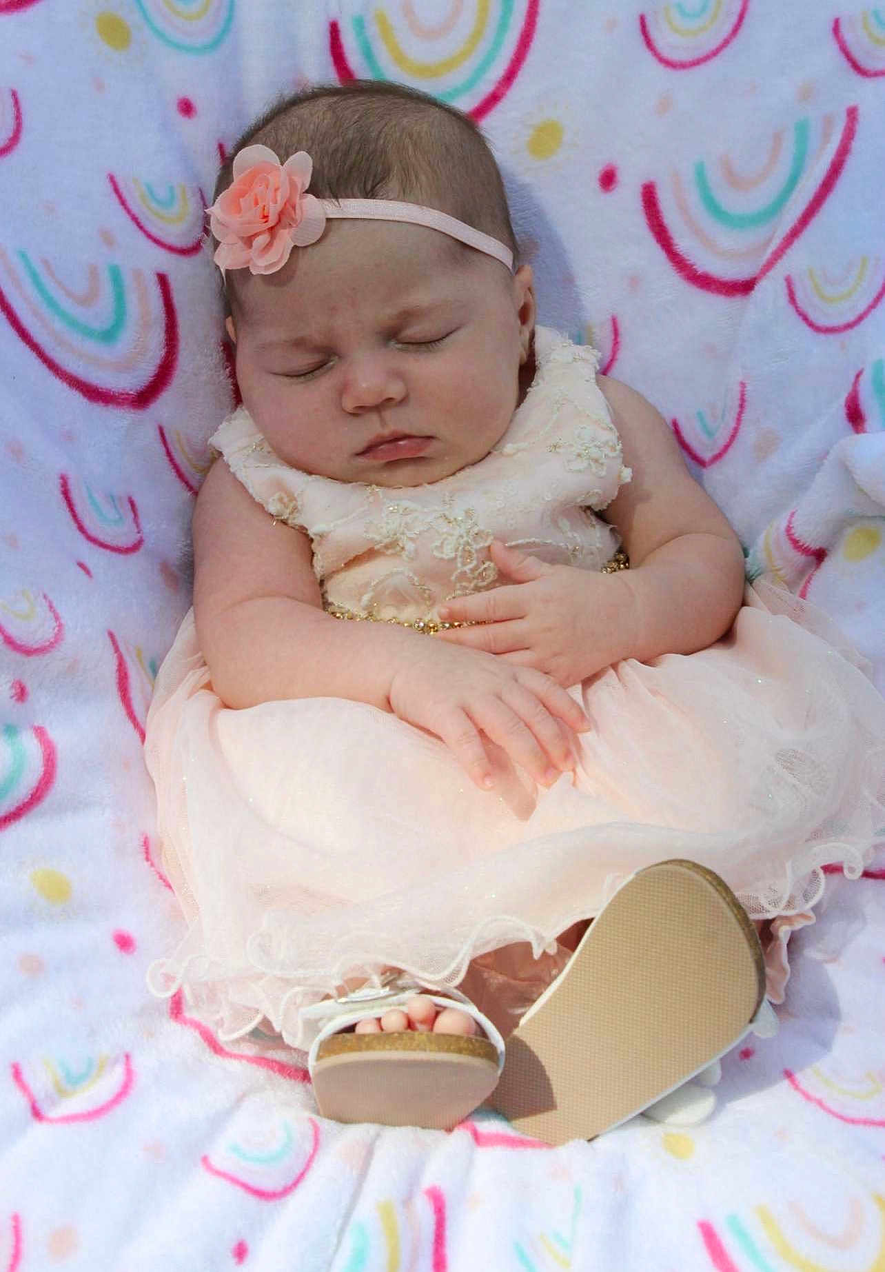Kaliyah is registered to the contest to win money with this photo: baby, sleeping, dress, headband, flower, blanket, pattern, footwear, sandals, infant, cute, peaceful, soft, pink, hands, feet, child, portrait, indoors, resting