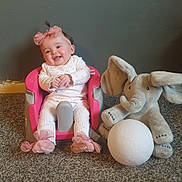 Lydia-Rose joined the competition — help win amazing prizes! baby, baby_seat, carpet, child, clothing, cute, floor, gray_wall, happy, headwear, indoors, infant, pink_headband, playful, plush_elephant, seated, smiling, socks, toy, white_ball