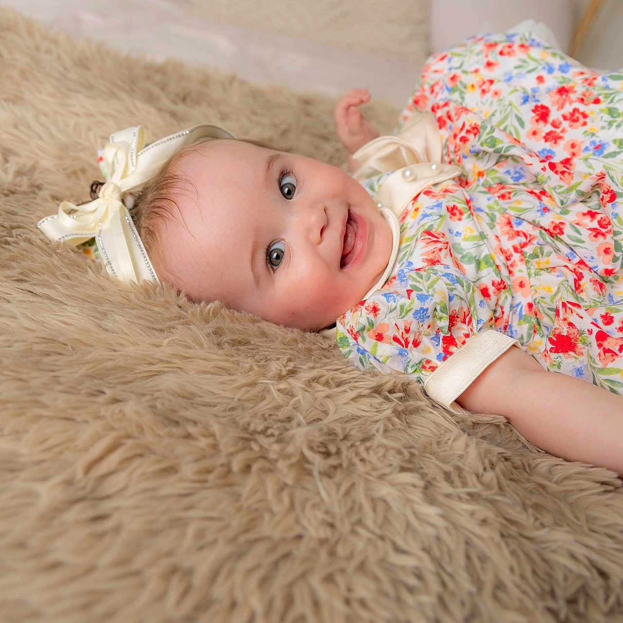 Lydia-Rose joined the competition — help win amazing prizes! baby, child, smile, floral_dress, bow, bracelet, lying_down, happy, cute, portrait, indoor, soft_rug, infant, person, skin, head, face, eyes, hand, apparel