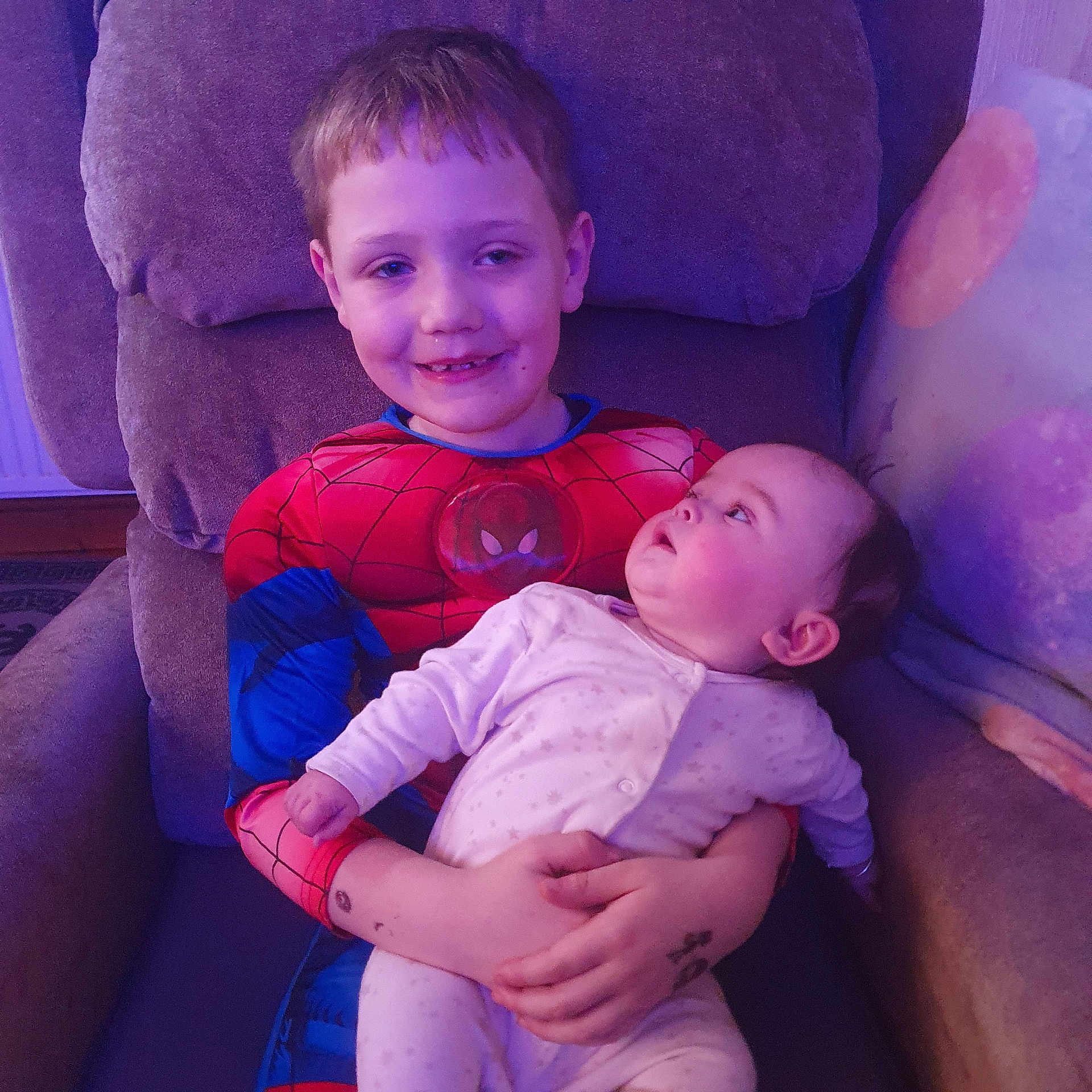 Roman-Paul joined the competition — help win amazing prizes! armchair, baby, child, cozy, cute, family, furniture, happy, holding, home, indoor, infant, pajamas, person, portrait, relaxed, sibling, smiling, spiderman_costume, toddler