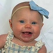 Haisley is registered to the contest to win money with this photo: baby, smiling, blue_eyes, headband, bow, dress, ruffles, infant, cute, happy, portrait, child, skin, face, person, indoors, closeup, young, sitting, white_background