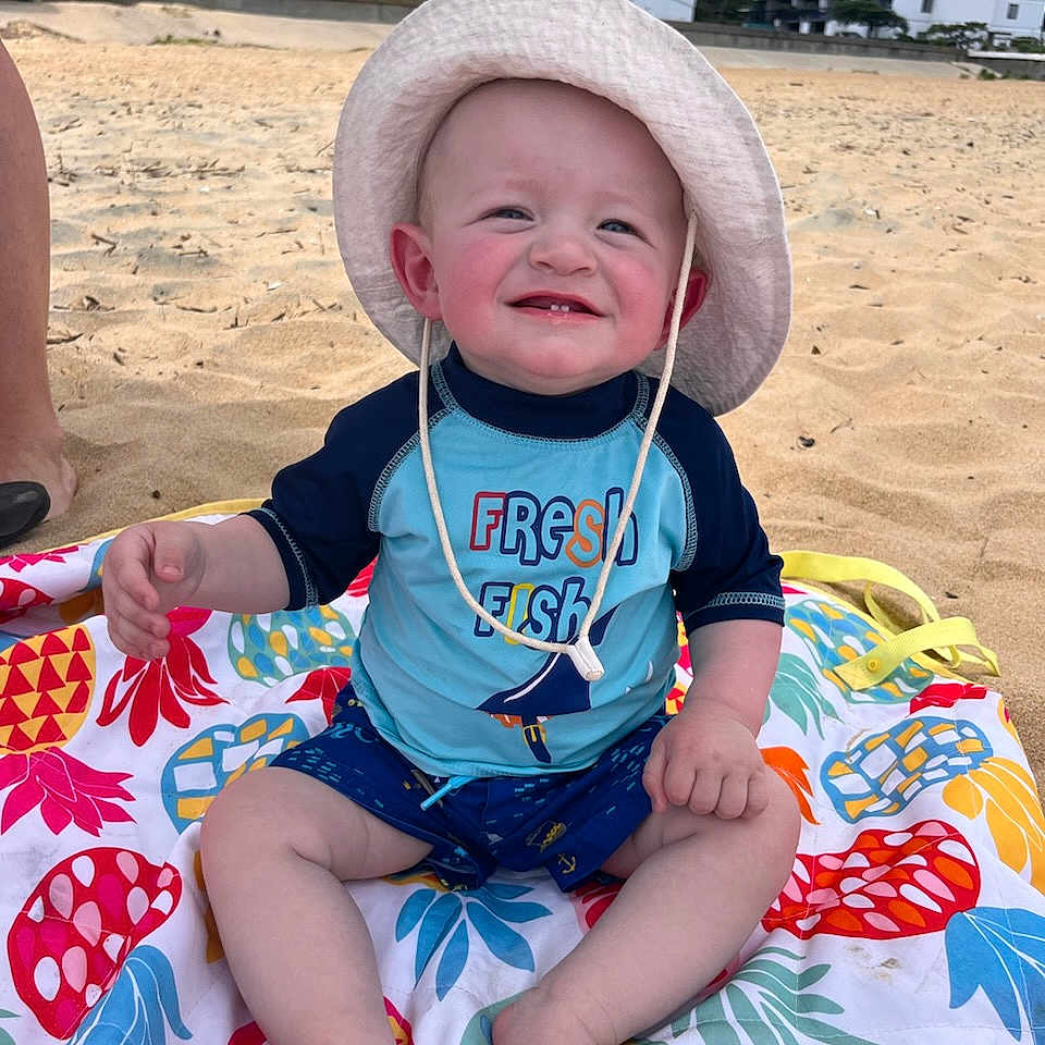 Danny joined the competition — help win amazing prizes! architecture, baby, beach, building, clothing, coast, face, hat, head, nature, outdoors, person, photography, portrait, sea, shoreline, shorts, soil, summer, water