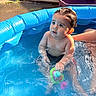 toddler, child, pool, water, toy, inflatable_pool, summer, sunlight, wet_hair, outdoor, playful, baby, sitting, colorful_toy, ripples, skin, face, cute, fun, relaxation