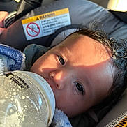 Xavian joined the competition — help win amazing prizes! baby, bottle, blanket, car_seat, child, face, feeding, fur, infant, milk, person, portrait, seatbelt, soft, sunlight, toddler, warm, young, closeup, caring