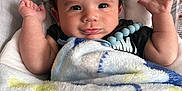Xavian joined the competition — help win amazing prizes! baby, infant, blanket, curly_hair, raised_hands, soft_toy, indoors, cute, portrait, child, smiling, black_shirt, pacifier_clip, furniture, cozy, happy, toddler, face, skin, expression
