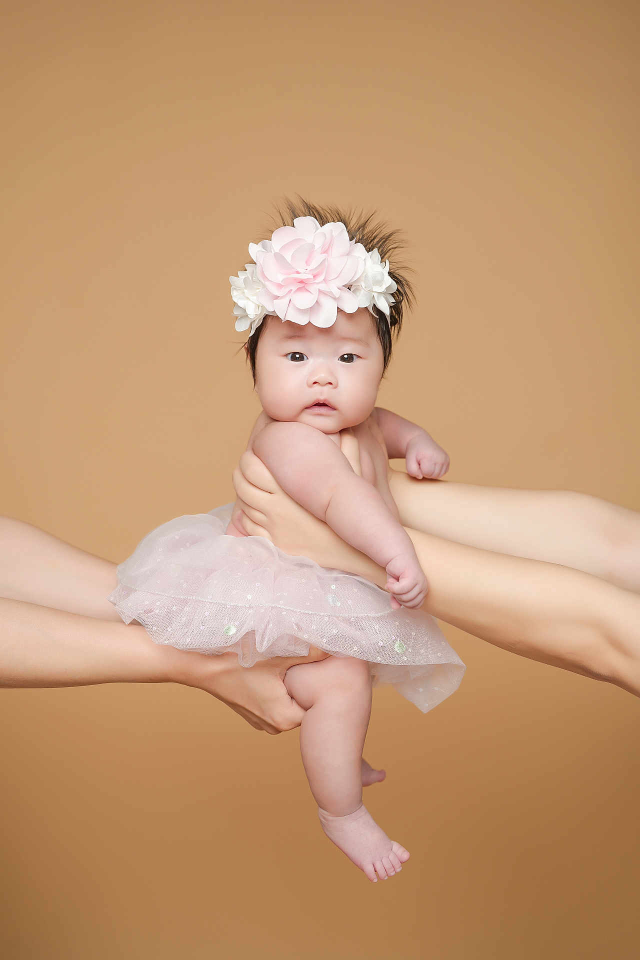 Olivia is registered to the contest to win money with this photo: baby, infant, flower_headband, pink_tutu, hands, arms, skin, cute, portrait, studio, soft_lighting, neutral_background, child, young, adorable, holding, expression, face, person, fashion