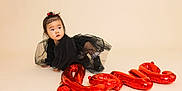 Olivia is registered to the contest to win money with this photo: toddler, child, baby, balloon, love, black_dress, boots, curious, crawling, studio, indoor, red, face, expression, hair_tie, cute, one_person, floor, neutral_background, portrait