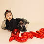 toddler, child, baby, balloon, love, black_dress, boots, curious, crawling, studio, indoor, red, face, expression, hair_tie, cute, one_person, floor, neutral_background, portrait