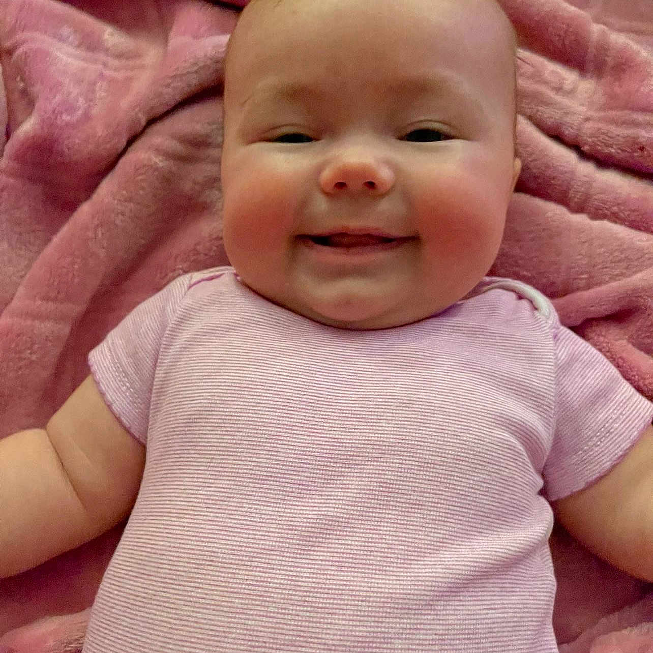 Nova is registered to the contest to win money with this photo: baby, babylaughing, blanket, bodypart, clothing, cushion, face, happy, head, homedecor, laughing, mouth, newborn, person, photography, portrait, quilt, shirt, smile, t_shirt