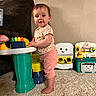 Cecelia is registered to the contest to win money with this photo: toddler, child, baby, toys, carpet, indoor, playtime, activity_table, plastic_toys, barefoot, clothing, wall, furniture, smiling_face, curious, standing, colorful, person, young_child, home