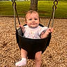 Cecelia joined the competition — help win amazing prizes! baby, child, swing, playground, wood_chips, grass, tree, outdoor, park, infant, smiling, clothing, white_socks, metal_chains, seat, nature, young, person, happy, daytime