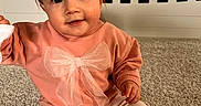 Cecelia is registered to the contest to win money with this photo: baby, child, infant, sitting, carpet, crib, pink_sweater, bow, pants, sock, foot, indoor, portrait, cute, smile, face, eyes, hand, furniture, home