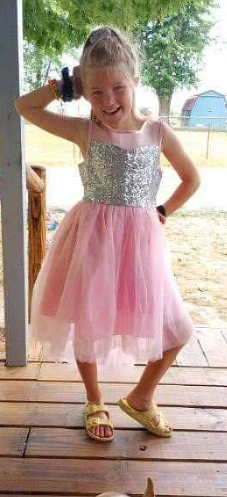 Danica is registered to the contest to win money with this photo: baby_toddler_clothing, blond, day_dress, event, fashion_accessory, happy, joy, magenta, neck, one_piece_garment, pattern, person, pink, purple, shoulder, sleeve, sleeveless_shirt, smile, thigh, trunk