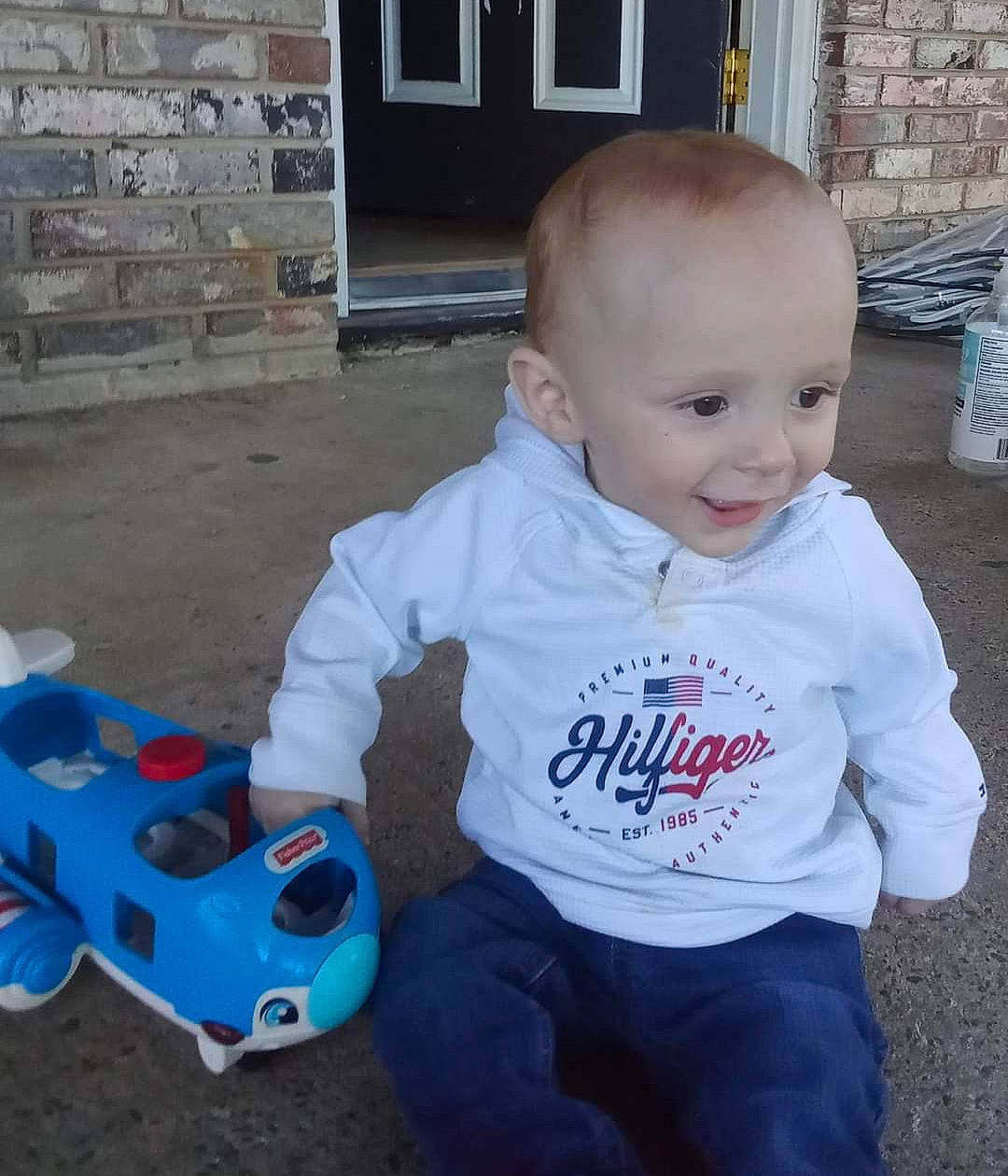 Kacen is registered to the contest to win money with this photo: baby, baby_toddler_clothing, blue, child, door, electric_blue, flooring, fun, game_controller, grass, happy, joy, person, plastic, sitting, sleeve, smile, t_shirt, toddler, toy