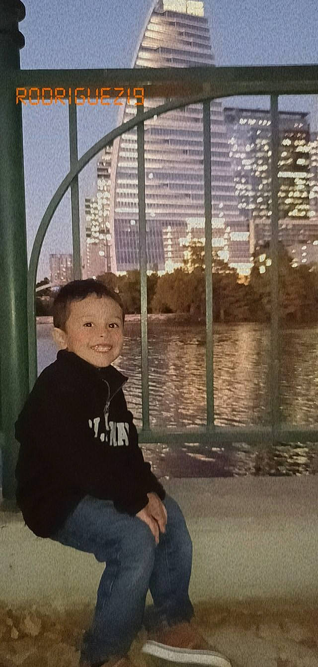 Diego is registered to the contest to win money with this photo: building, child, city, condominium, fun, glass, happy, hoodie, jeans, joy, leisure, metal, person, recreation, reflection, sitting, smile, t_shirt, tints_and_shades, toddler