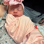 Reese joined the competition — help win amazing prizes! newborn, baby, sleeping, pink, bow, hat, fabric, wrapped, person, jeans, hand, closeup, indoor, soft, peaceful, infant, portrait, cute, resting, child