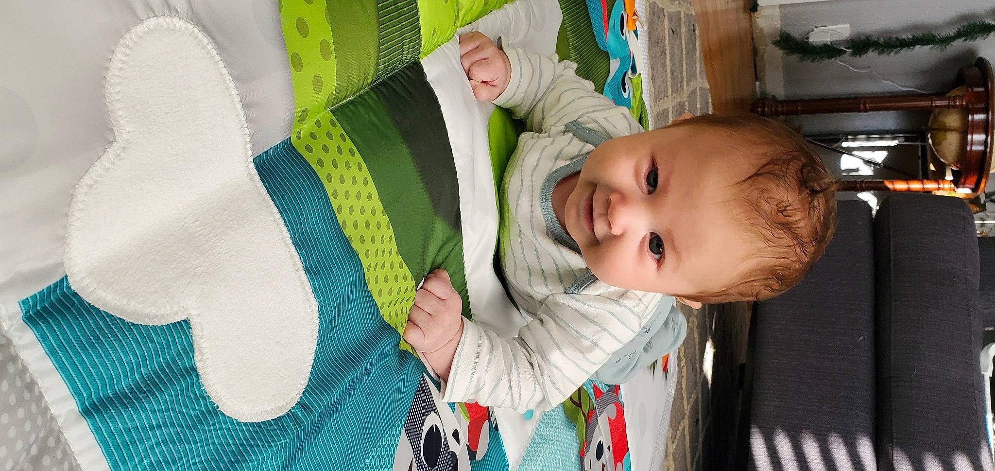 Drake is registered to the contest to win money with this photo: baby, baby_products, baby_toddler_clothing, cheek, child, comfort, facial_expression, fun, green, hairstyle, happy, joy, mouth, nose, outerwear, person, sitting, skin, smile, textile