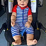 baby, child, smiling, stroller, striped_clothing, red, blue, footwear, happy, sitting, infant, cute, baby_outfit, young_child, person, legs, feet, indoor, portrait, bright