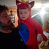 Oakley joined the competition — help win amazing prizes! child, toddler, costume, dragon, red, blue, man, beard, indoor, home, wood_paneling, lighting, holding, wings, hood, cute, portrait, family, person, cozy